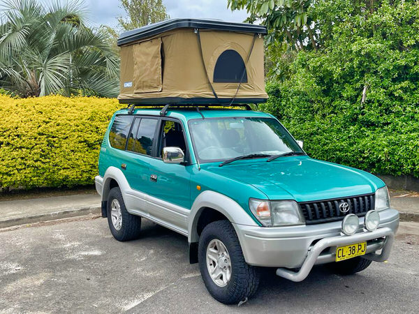 Used Toyota Prado for Sale - Automatic Model with Roof tent - photo showing the front drivers side angle view with bullbars and roof tent open