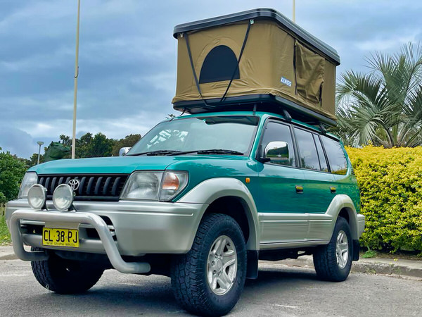 Used Toyota Prado for Sale - Automatic Model with Roof tent - photo showing the front passengers side angle view with bullbars and roof tent open