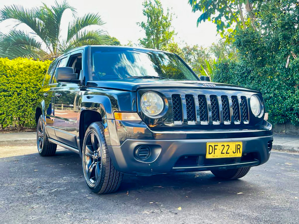 Used Jeep Patriot for sale - 2013 Automatic Jet Black Model - photo showing the front drivers side angle view with black alloy wheels