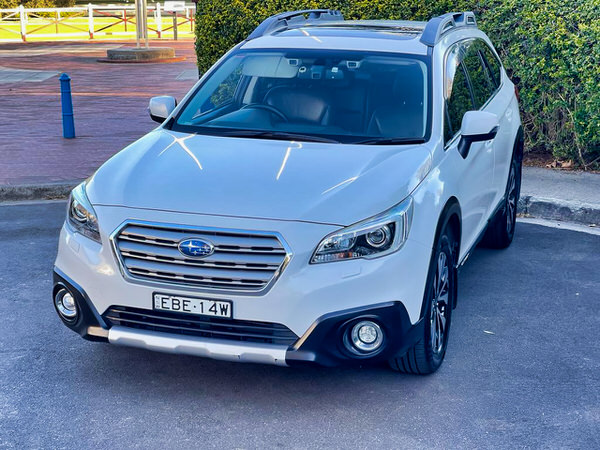 Used Subaru for sale - Fantastic Online Customer Reviews - Model shown is the 2016 white Turbo Diesel Subaru Outback - Photo showing the front passengers side view with spotlights and roofrack