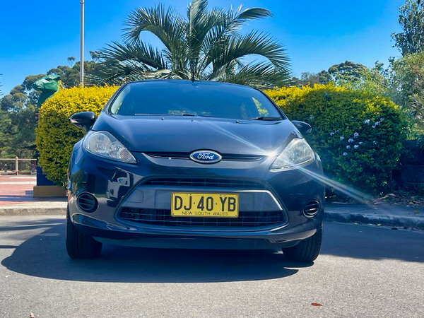 Used Ford Fiesta for sale in Sydney - 2012 Model in Black in great condition - Photo showing the front straight on view with matching colour coded from bumper and grille 