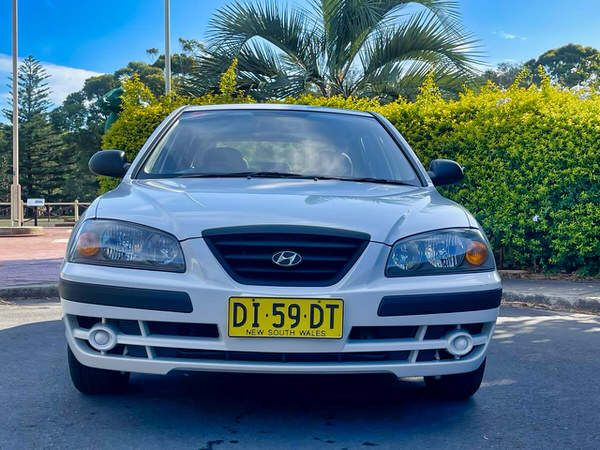 Used Hyundai Elantra For Sale in Sydney - Model shown is white automatic 2004 model - photo straight on view with colour matching front bumper and grille