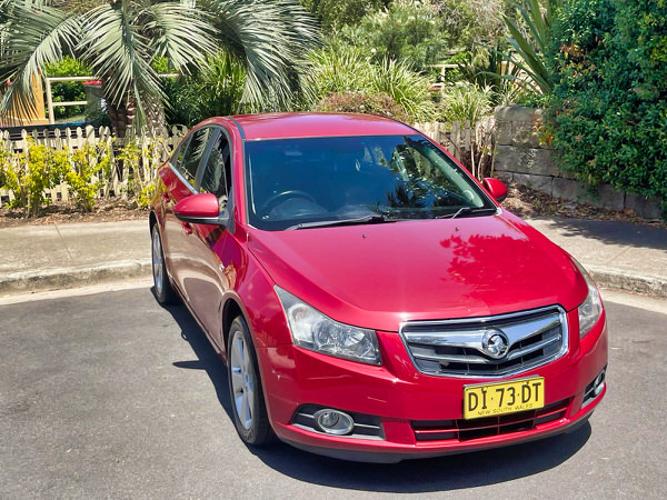 Used Holden Cruze for sale in Sydney - Automatic 2010 Maroon model - Photo showing front drivers side of the vehicle shot from a low angle