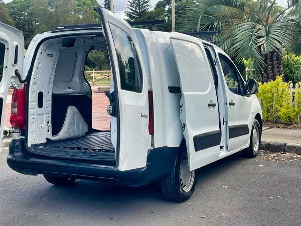 Used Citroen Berlingo for sale in Sydney. White 2011 Diesel model with twin side sliding doors. Photos shows the view of the cargo area with both rear doors and both side doors open showing how practical this van is 