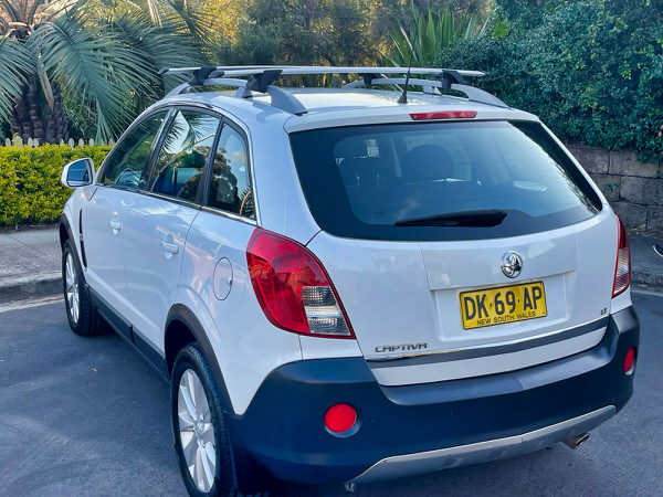 Used Holden Captiva for sale in Sidney - automatic five seater model - photo showing the rear passengers side angle view showing the roof rack bars