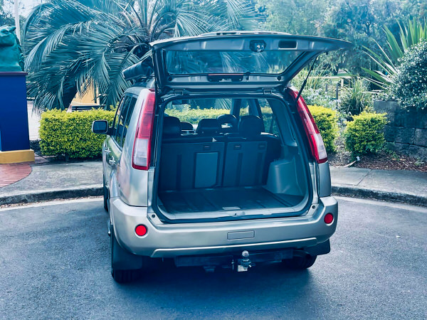Small SUV for sale - Nissan X-Trail 2004 Model with twin headlamps - Photo showing the rear tailgate open and plenty of storage space in the rear of the vehicle