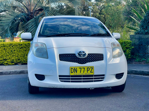 Used Toyota Yaris for sale at Sydneycars in Botnay - White 2006 model in good condition - Photo showing the front straight on view with colour matching front bumper and grille
