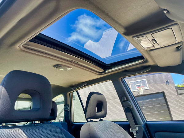 used Toyota Rav4 for sale in Sydney - Model shown in the photo is a Toyota RAV4 Cruiser 2005 model in Silver with Roof Rack and Roo bars - Photo showing the view of the sunroof in the back of the vehicle