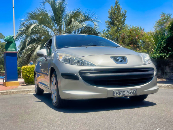 Used Peugeot 207 for sale in Sydney - Model shown is an Automatic 207 in Silver - photo is of the front driver side angle view with colour matching front bumper and grille