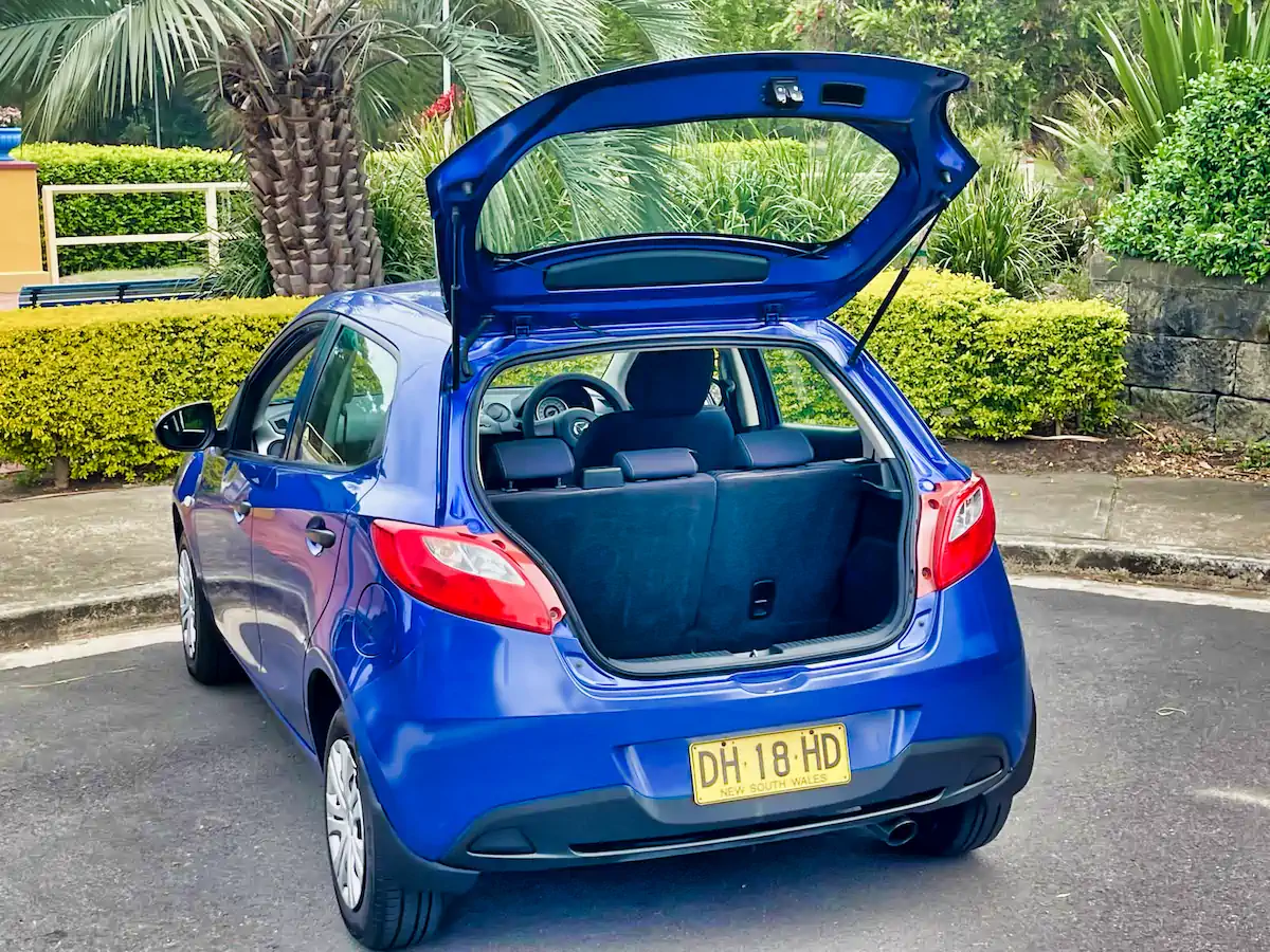 Rear tailgate open showing big boot space for a small Mazda 2 in blue
