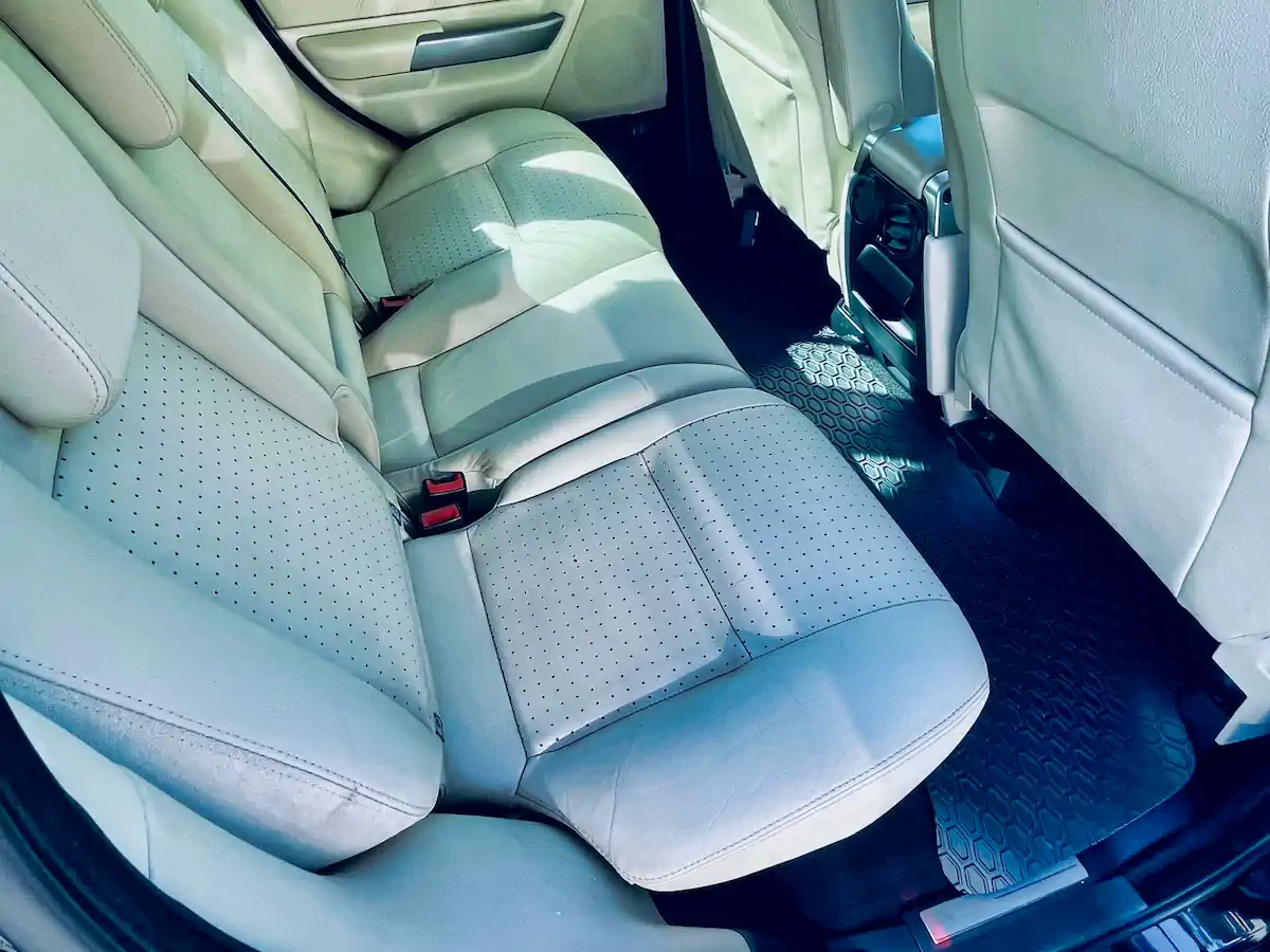 Rear passenger cabin of used Range Rover showing premium cream leather seats in pristine condition.